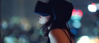 Woman using virtual reality headset at night with city lights in background