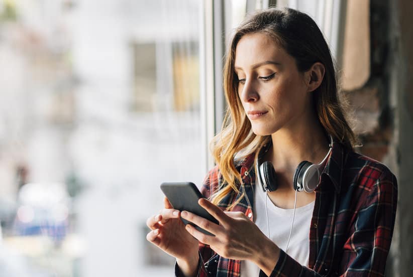 Young businesswoman in the office using her smart phone.