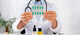 doctor holding pills with cbd oils in front of her