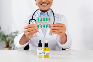 doctor holding pills with cbd oils in front of her