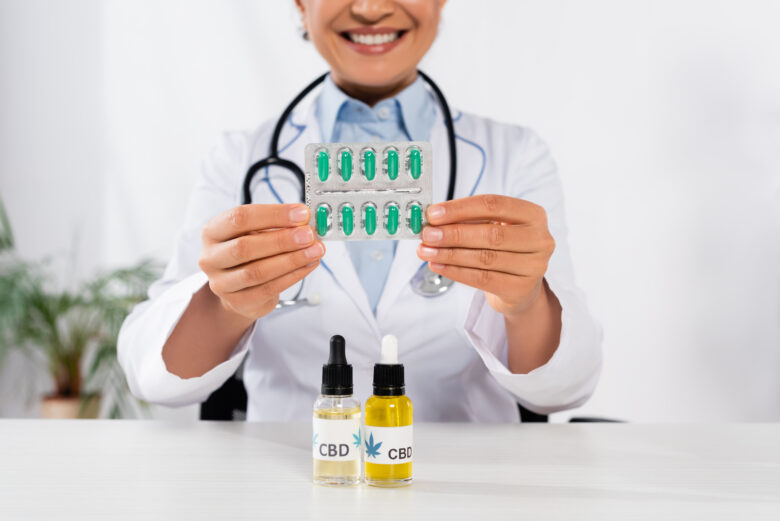 doctor holding pills with cbd oils in front of her