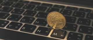 gold coin on laptop keyboard
