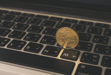 gold coin on laptop keyboard