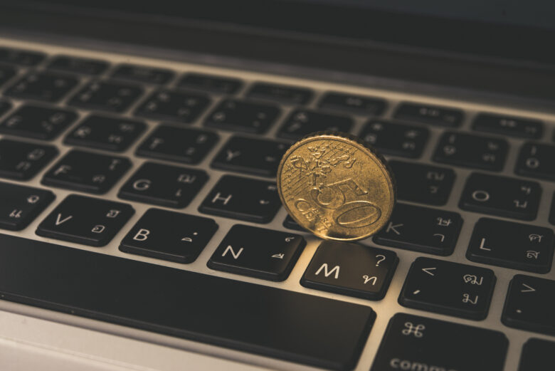 gold coin on laptop keyboard