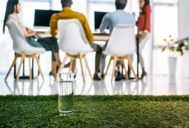 people sitting around conference table with artificial turf in the background