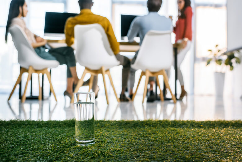 people sitting around conference table with artificial turf in the background