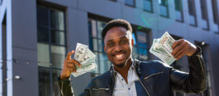 Happy entrepreneur with handfuls of money