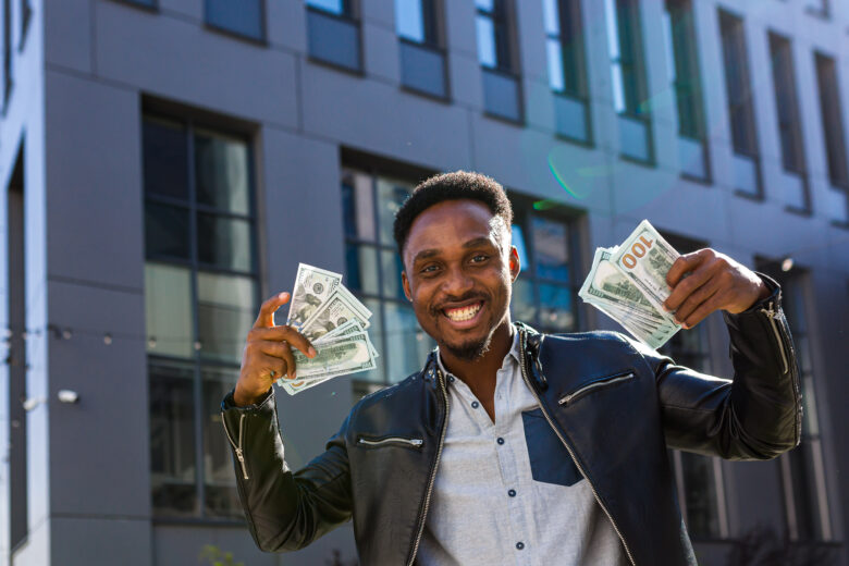 Happy entrepreneur with handfuls of money