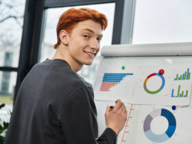 Young redheaded man looking at graphs and charts