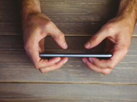 person holding phone on wood background