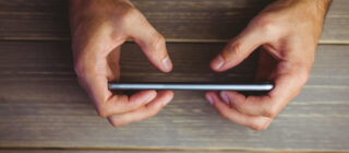 person holding phone on wood background