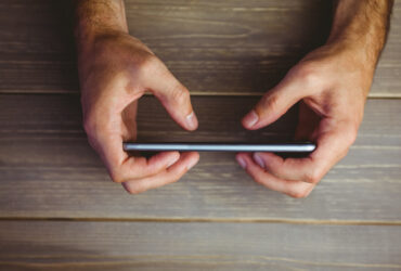 person holding phone on wood background