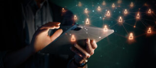 hands using tablet with holographic icons around it