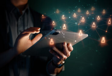 hands using tablet with holographic icons around it