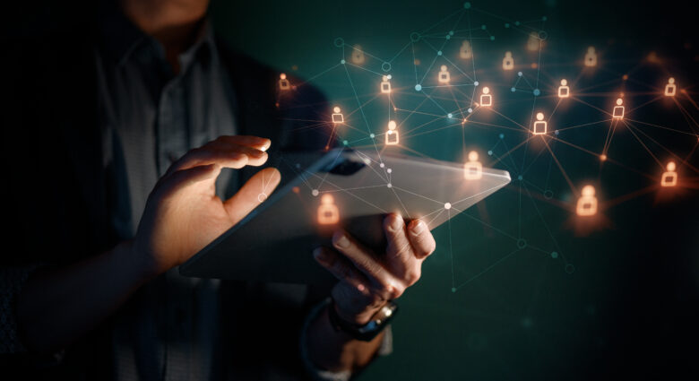 hands using tablet with holographic icons around it