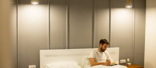 man in minimalist bedroom with lighting