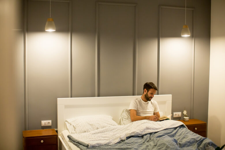 man in minimalist bedroom with lighting