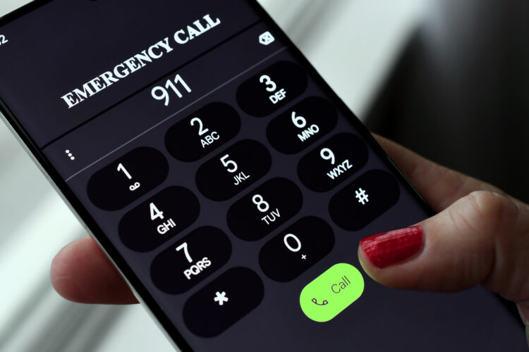 hand dialing 911 on phone