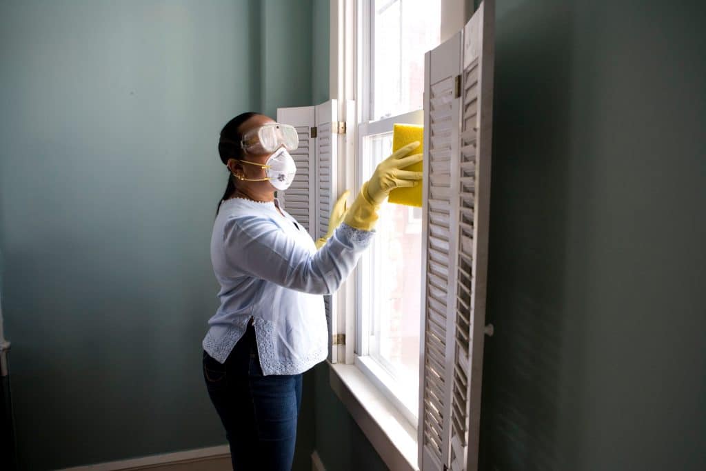 woman cleaning windows in a house