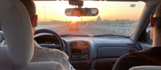 Man driving into sunset