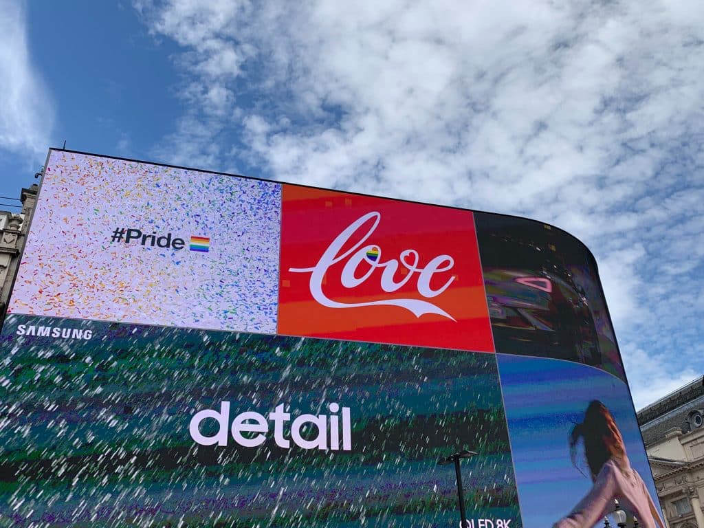 massive screens on curved building advertising samsung, coke, and other brands