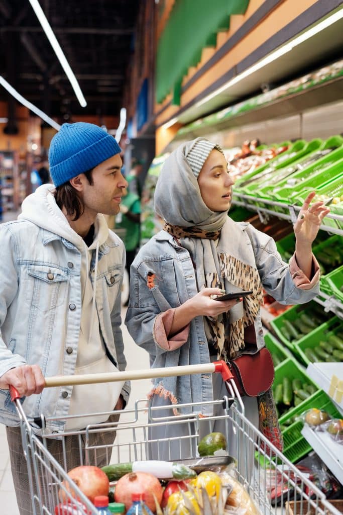 a couple shopping for vegetables in the grocery store