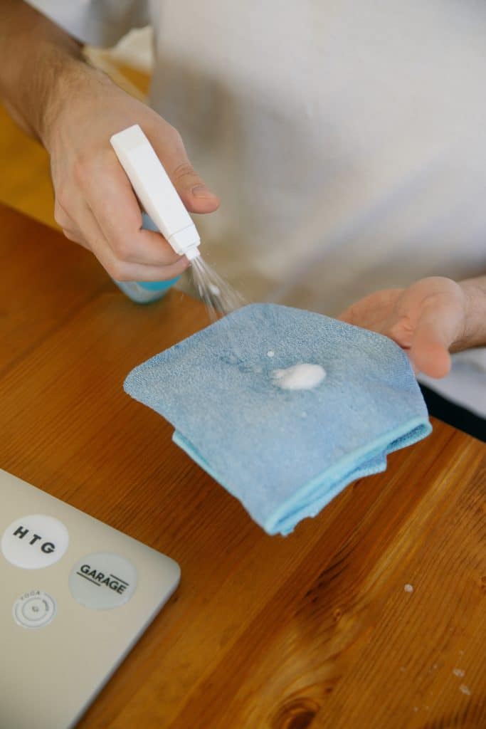 a man spraying a washcloth with cleaning solution