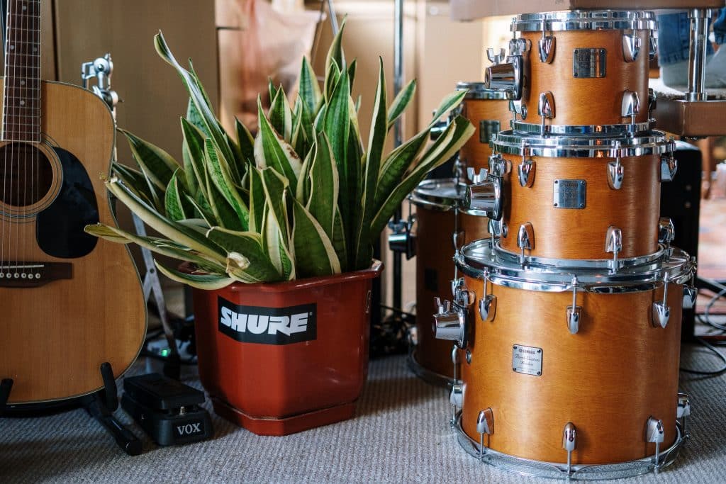 drum set stacked on a carpet with guitar