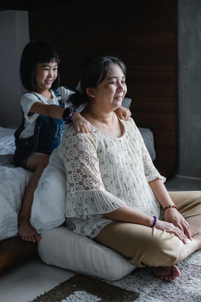 little girl rubbing her grandmother's shoulders