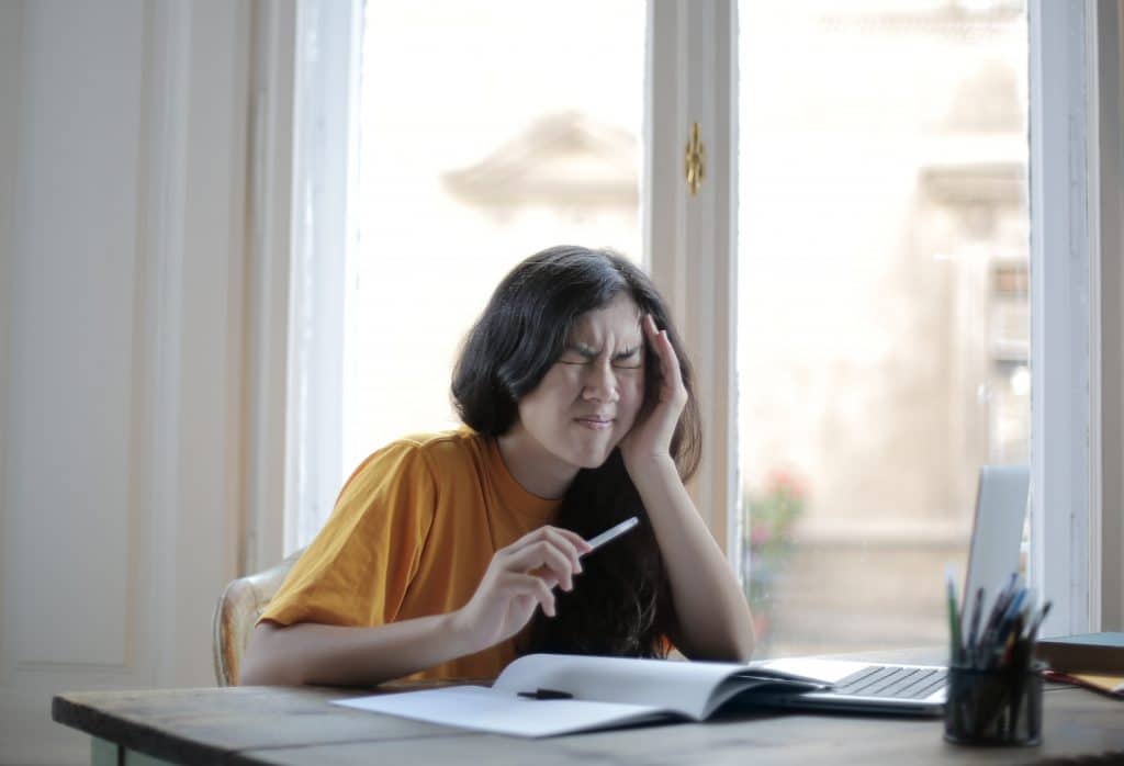 woman trying to work while suffering from a headache