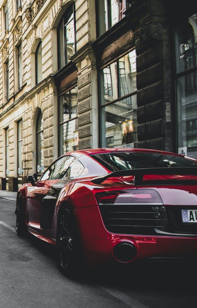 fancy, red sports car parked on a city street