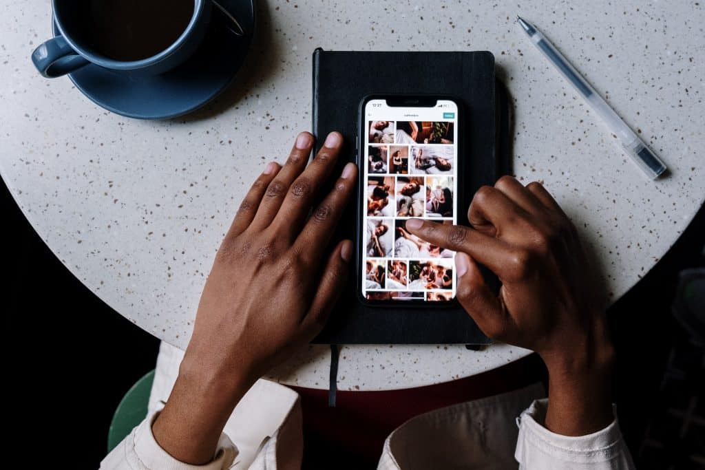 someone sitting at a table scrolling through Instagram photos