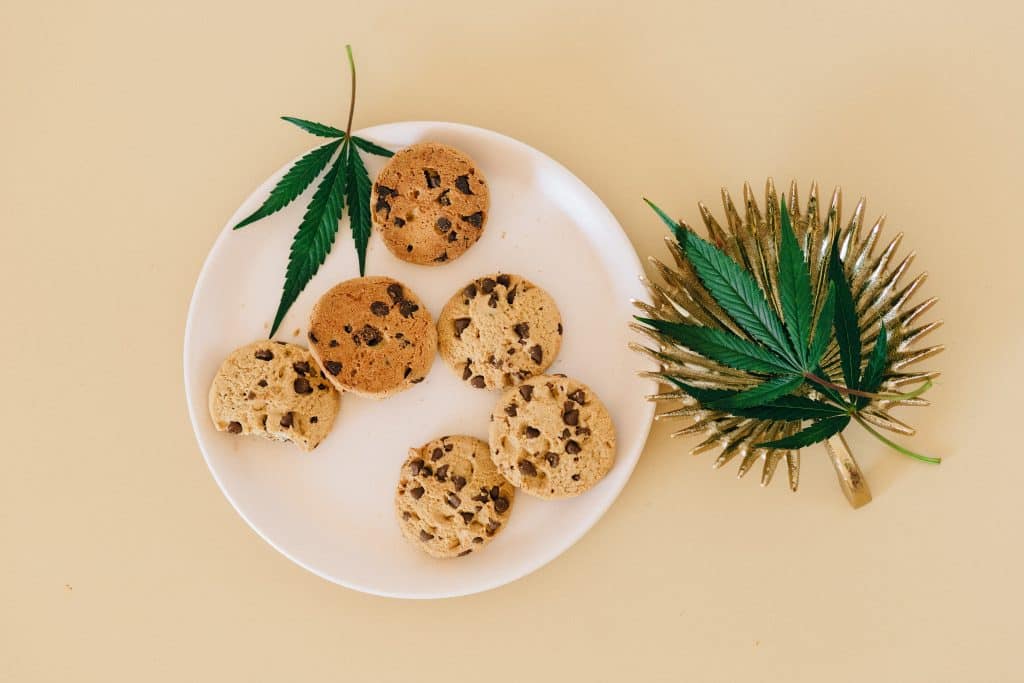 a plate of cookies laid out with cannabis leaves