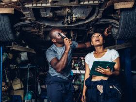 Mechanics examining car