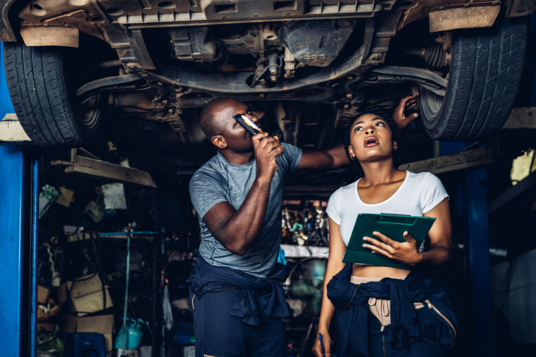 Mechanics examining car