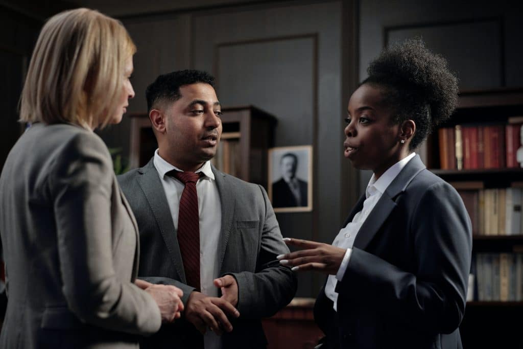 lawyer discussing a case with two other people in a library