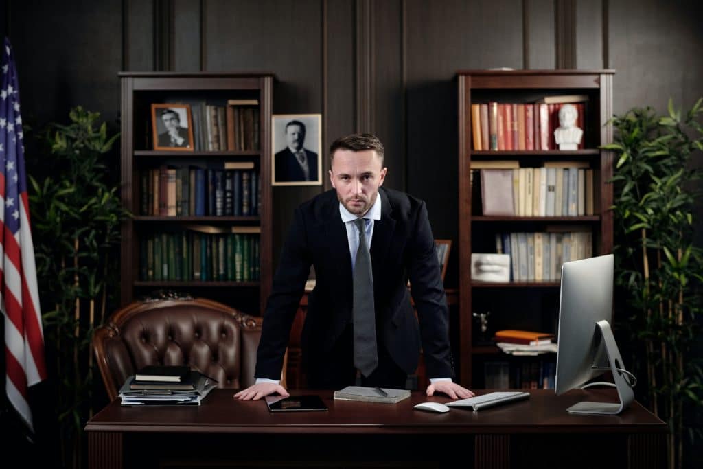 lawyer leaning on his desk in his office