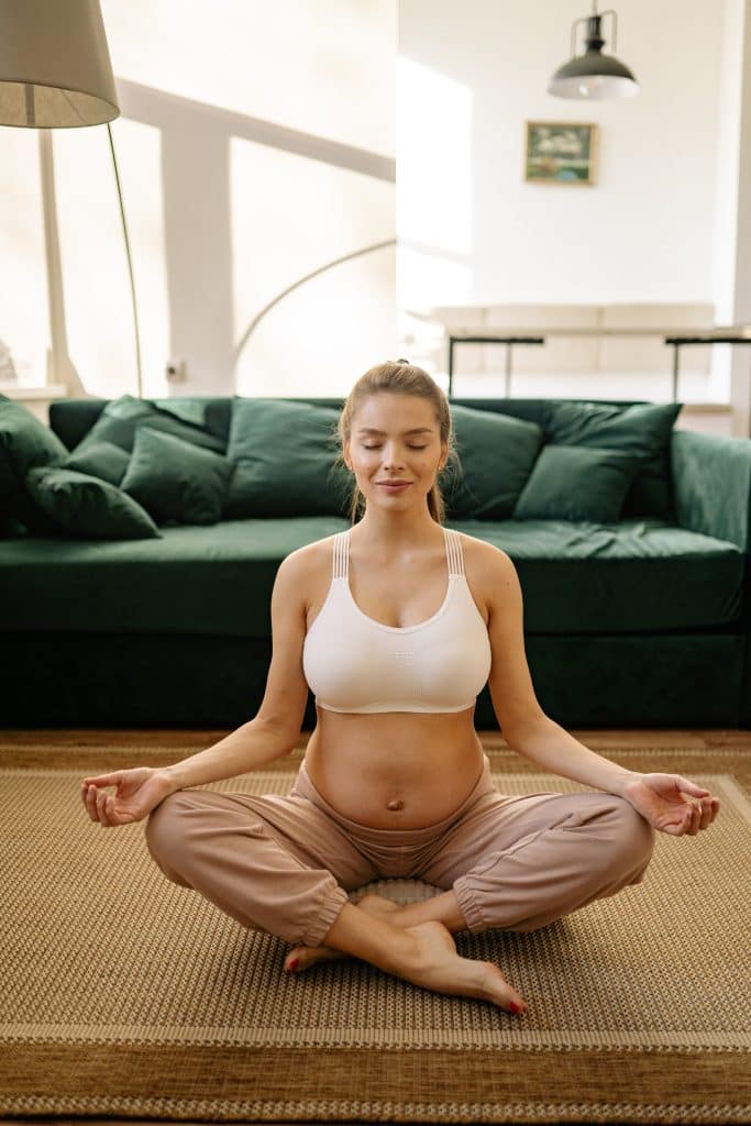 pregnant woman sitting in a meditation position on the floor