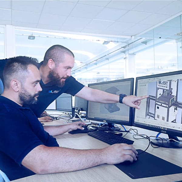 two men looking at a diagram of a LASIT machine displayed on a monitor