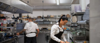 female chef cutting vegetables in kitchen