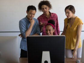 People gathered in front of computer.