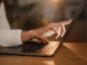 woman's hands typing on laptop