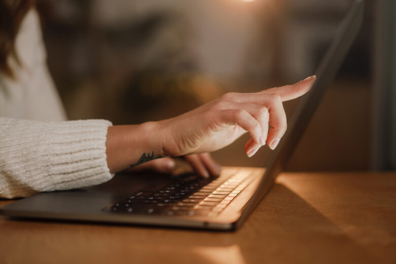 woman's hands typing on laptop