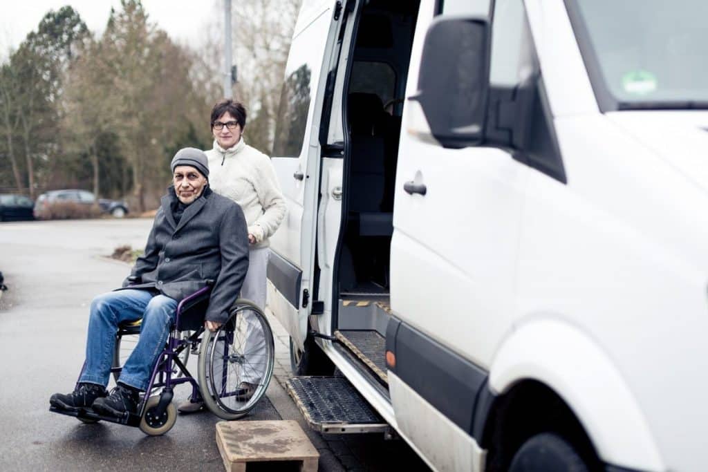 elderly man in a wheelchair being transported in a van