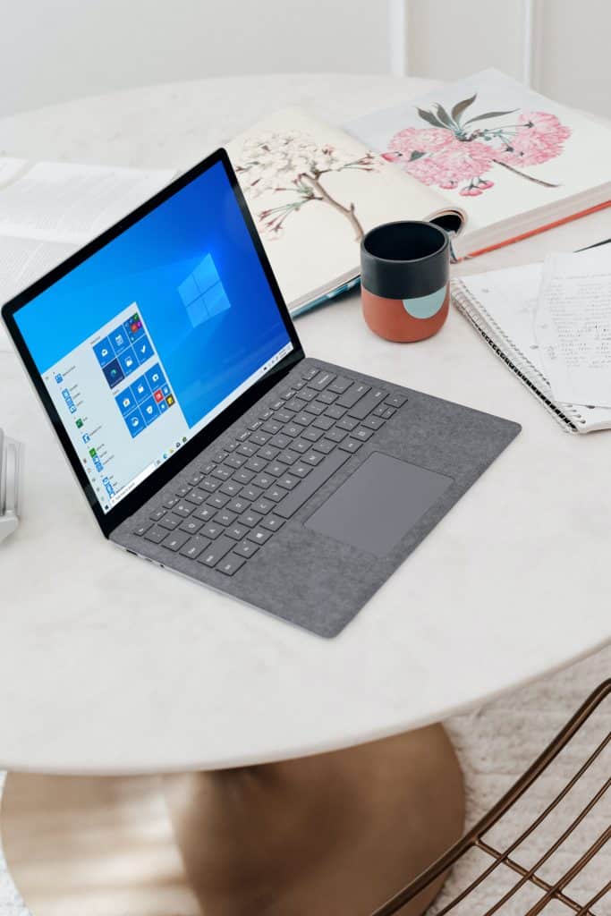laptop on table displaying the Windows start menu