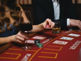 elegant man and woman playing poker in a casino and drinking wine