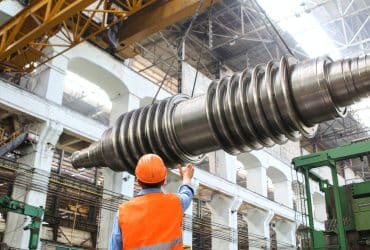 man standing beside heavy equipment