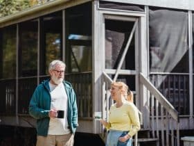 retired couple having coffee outside cabin