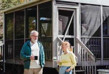 retired couple having coffee outside cabin