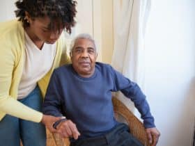 home health aide helping elderly man